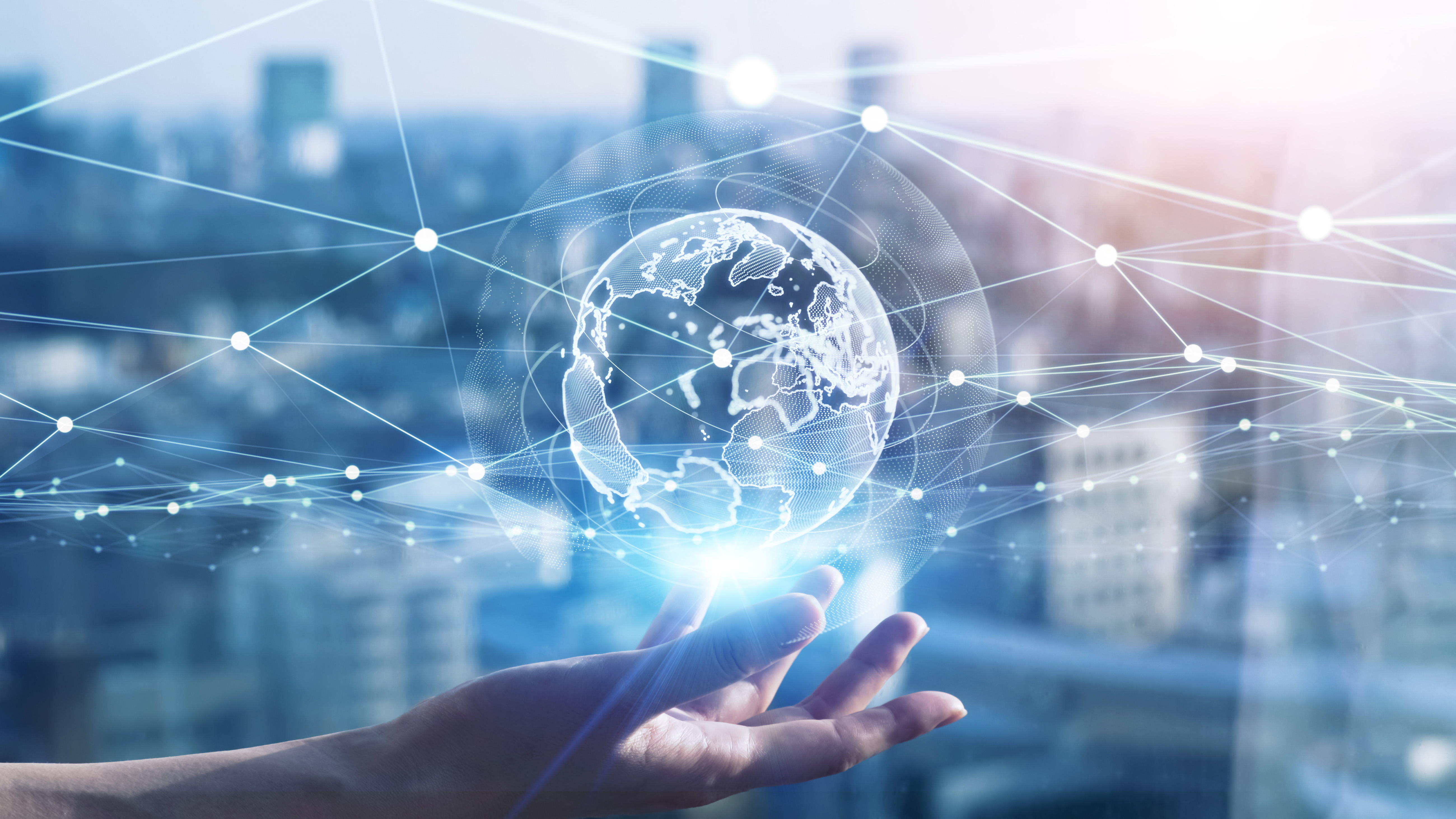 A globe held in a hand with a network of global connections